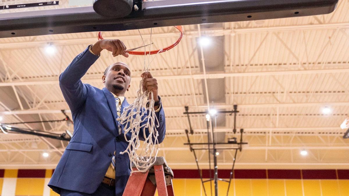 Harding’s former head coach LJ Johnson, and new Indian Land head coach, cuts the net after winning against Ardrey Kell for the SoMECK conference tournament championship game at Harding High School on Friday, February 18, 2022.