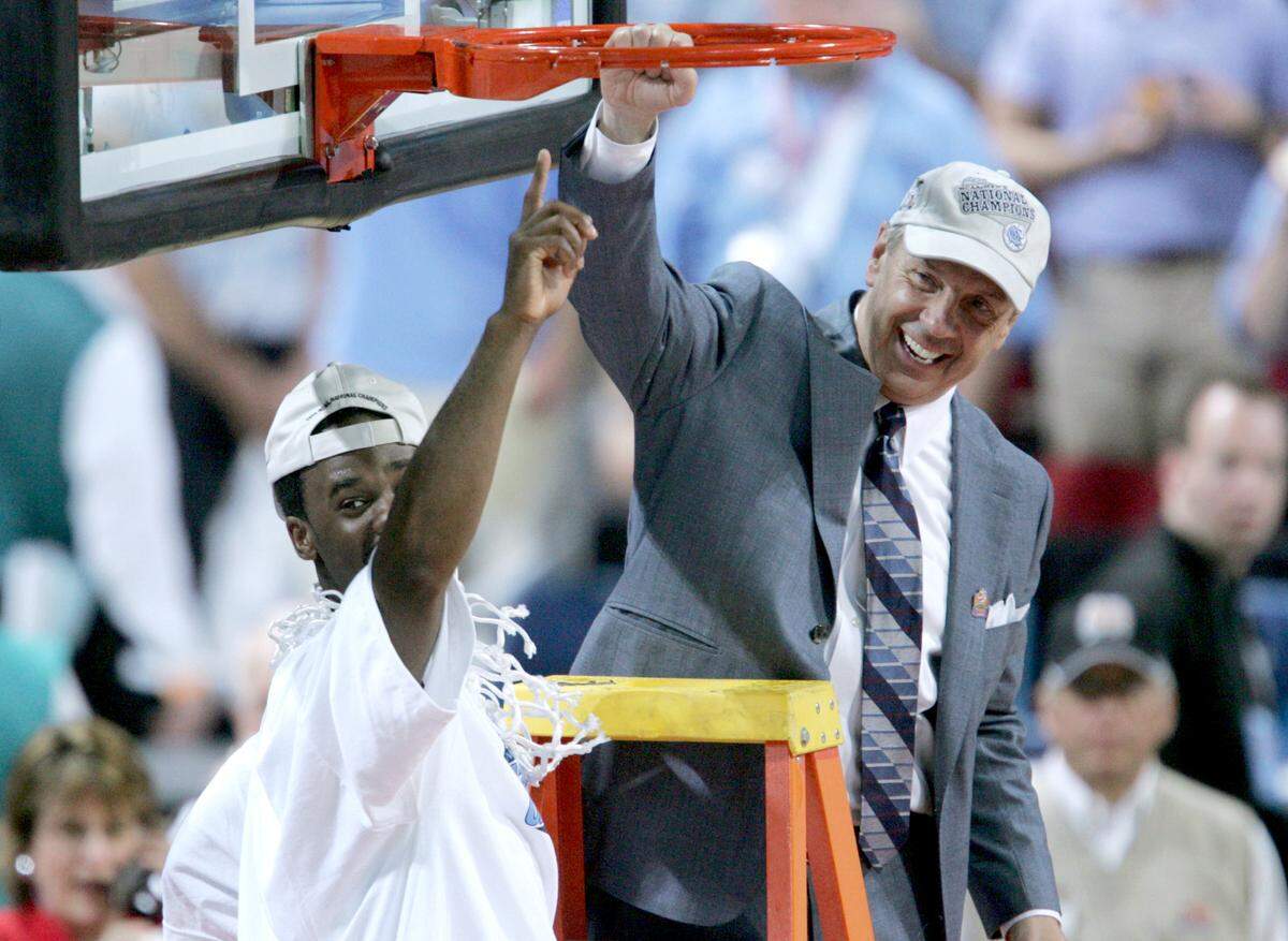 UNC’s Roy Williams celebrates with Melvin Scott after cutting down the net after North Carolina defeated Illinois 75-70 to win the National Championship on April 4, 2005 at the Edward Jones Dome in St. Louis.