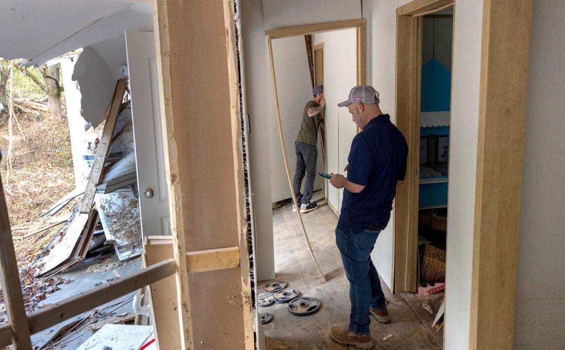 FEMA employee Jirau Alvaro works with Daniel Mancini, documenting the damage to his property near Black Mountain, N.C.