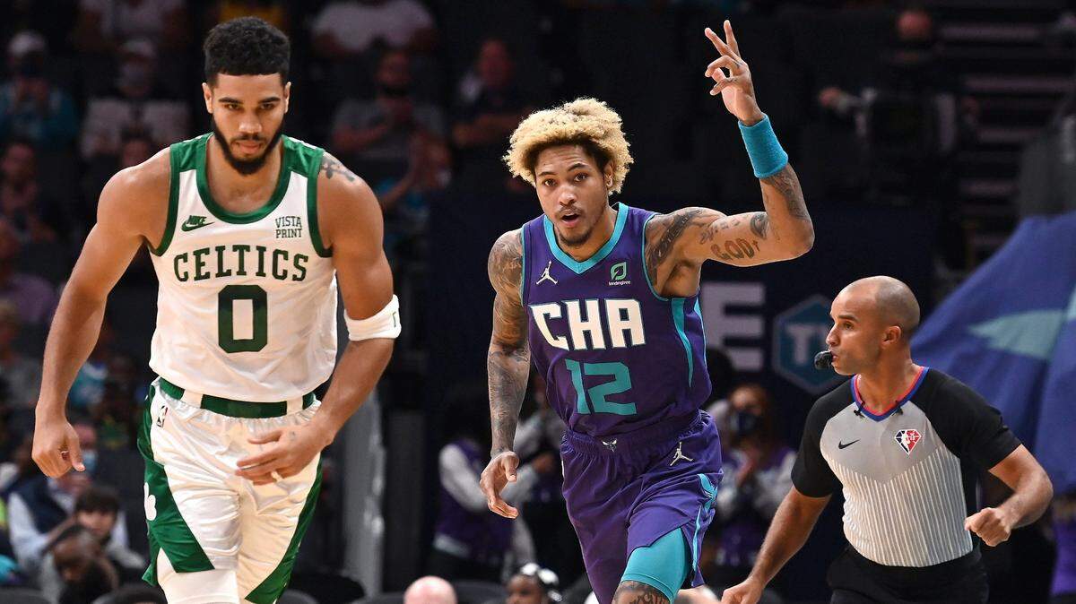 Charlotte Hornets forward Kelly Oubre Jr., center, signals his three-point basket as Boston Celtics forward/guard Jayson Tatum, left, turns to run downcourt during a game in October. Oubre returned from COVID protocols for the Hornets’ game in Boston on Wednesday night.
