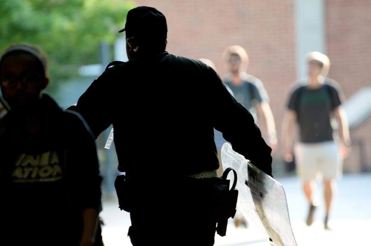 A UNC Charlotte police officer with a tactical shield responds in the immediate aftermath of the campus shooting on April 30.