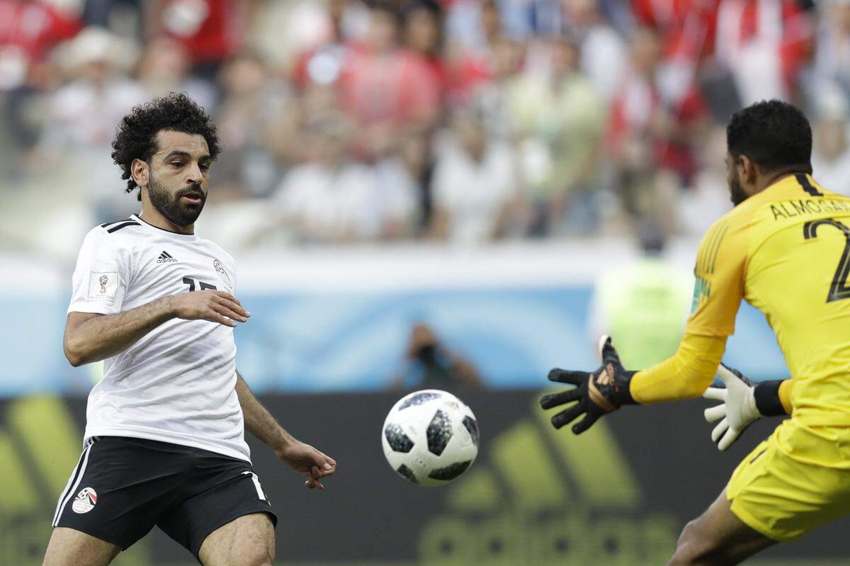 Egypt’s Mohamed Salah, left, challenge for the ball with Saudi Arabia goalkeeper Yasser Almosailem during the group A match between Saudi Arabia and Egypt at the 2018 soccer World Cup at the Volgograd Arena in Volgograd, Russia, Monday, June 25, 2018. (AP Photo/Andrew Medichini)