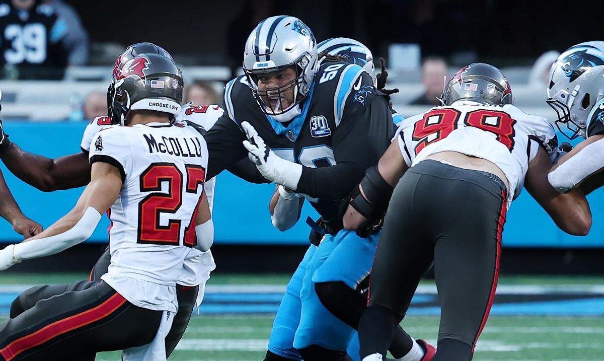 Carolina Panthers guard Robert Hunt, center, blocks a Tampa Bay Buccaneers defender during action at Bank of America Stadium in Charlotte, NC on Sunday, December 1, 2024. The Buccaneers defeated the Panthers in overtime 26-23.