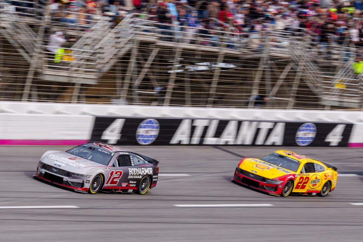 Feb 23, 2025; Hampton, Georgia, USA; Ryan Blaney (12) and Joey Logano (22) come through turn four at Atlanta Motor Speedway.