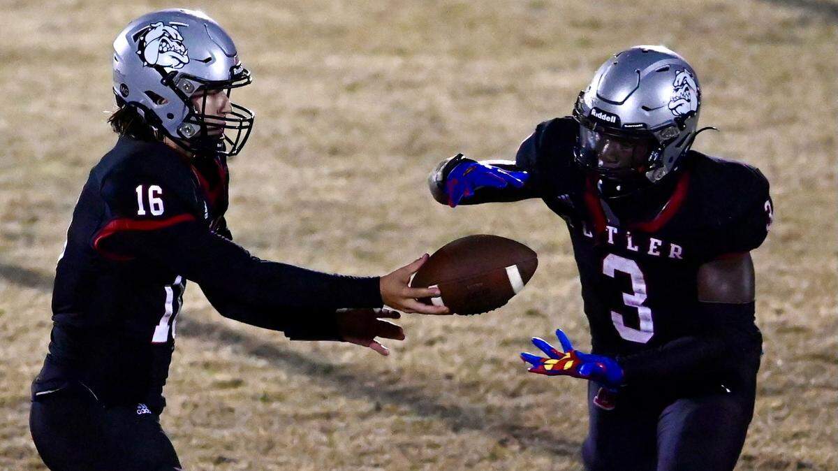 Butler Bulldogs quarterback Zach Lawerence, left, hands the ball off to running back DJ Horton, right, during second half action against Hickory Ridge on Friday, November 4, 2022. Jeff Siner/The Charlotte Observer