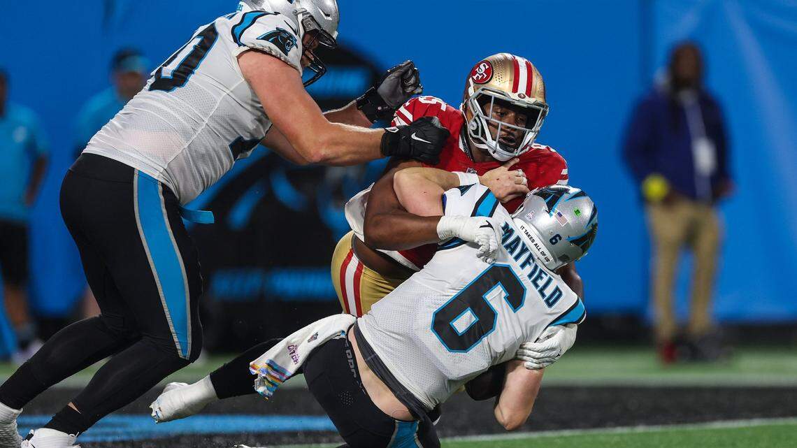 Panthers quarterback Baker Mayfield, bottom right, is sacked by 49ers defensive lineman Drake Jackson during the game at Bank of America Stadium on Sunday, October, 9, 2022. The 49ers beat the Panthers, 37-15.