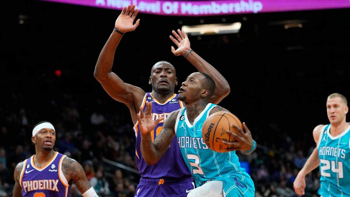Charlotte Hornets guard Terry Rozier (3) drives past Phoenix Suns center Bismack Biyombo (18) during the first half of an NBA basketball game, Tuesday, Jan. 24, 2023, in Phoenix. (AP Photo/Matt York)