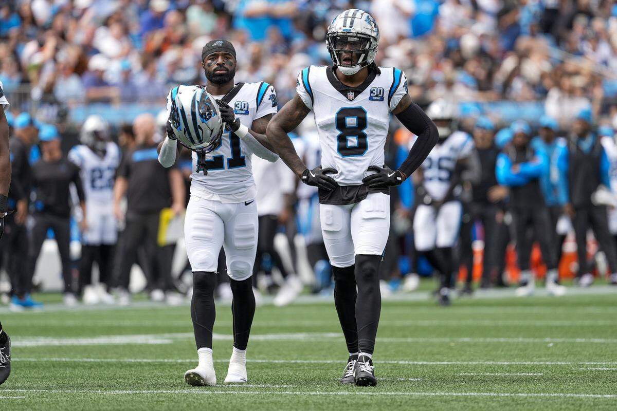 Sep 29, 2024; Charlotte, North Carolina, USA; Carolina Panthers safety Nick Scott (21) and cornerback Jaycee Horn (8) take the field during 1st quarter against the Cincinnati Bengals at Bank of America Stadium. Mandatory Credit: Jim Dedmon-Imagn Images
