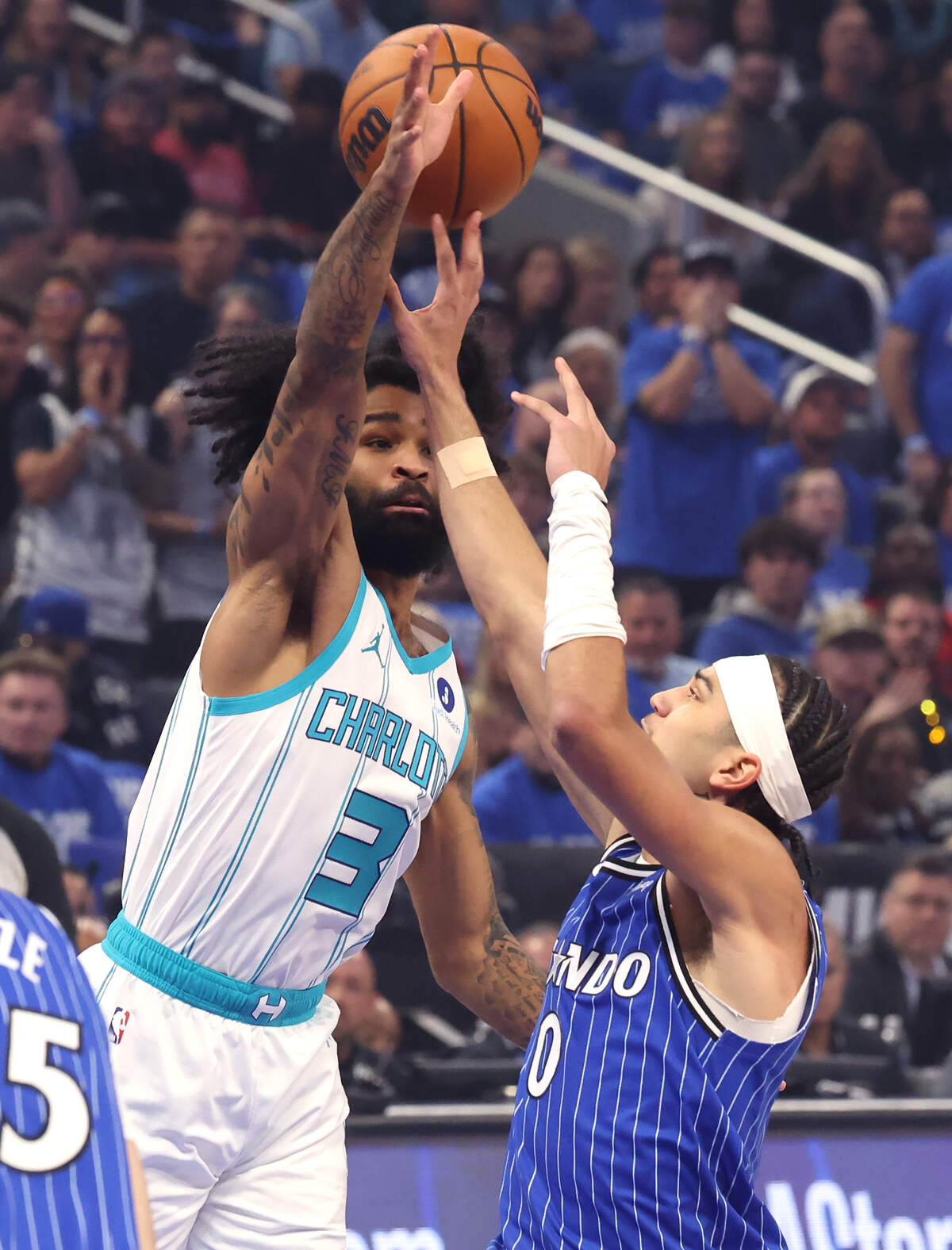 Charlotte Hornets guard Coby White, left, looks to block a pass by Orlando Magic guard Anthony Black, right, during action at Kia Center in Orlando, FL on Friday, April 17, 2026.