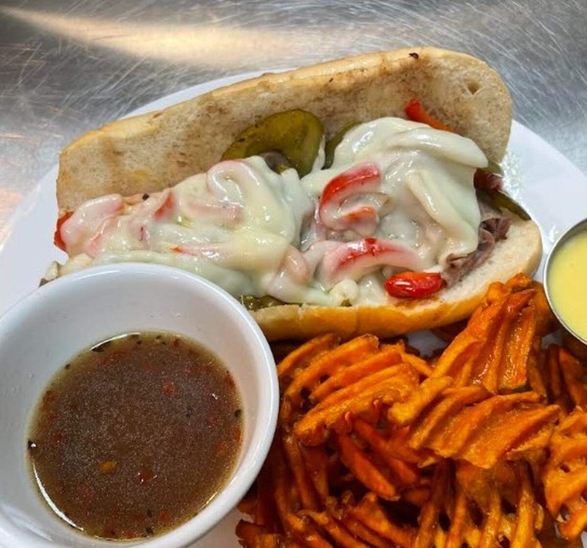The Happy Italian Cheese & Beef sandwich includes beef, provolone, peppers and onions on a hoagie, with chef-owner Cornelio Garcia’s homemade au jus.