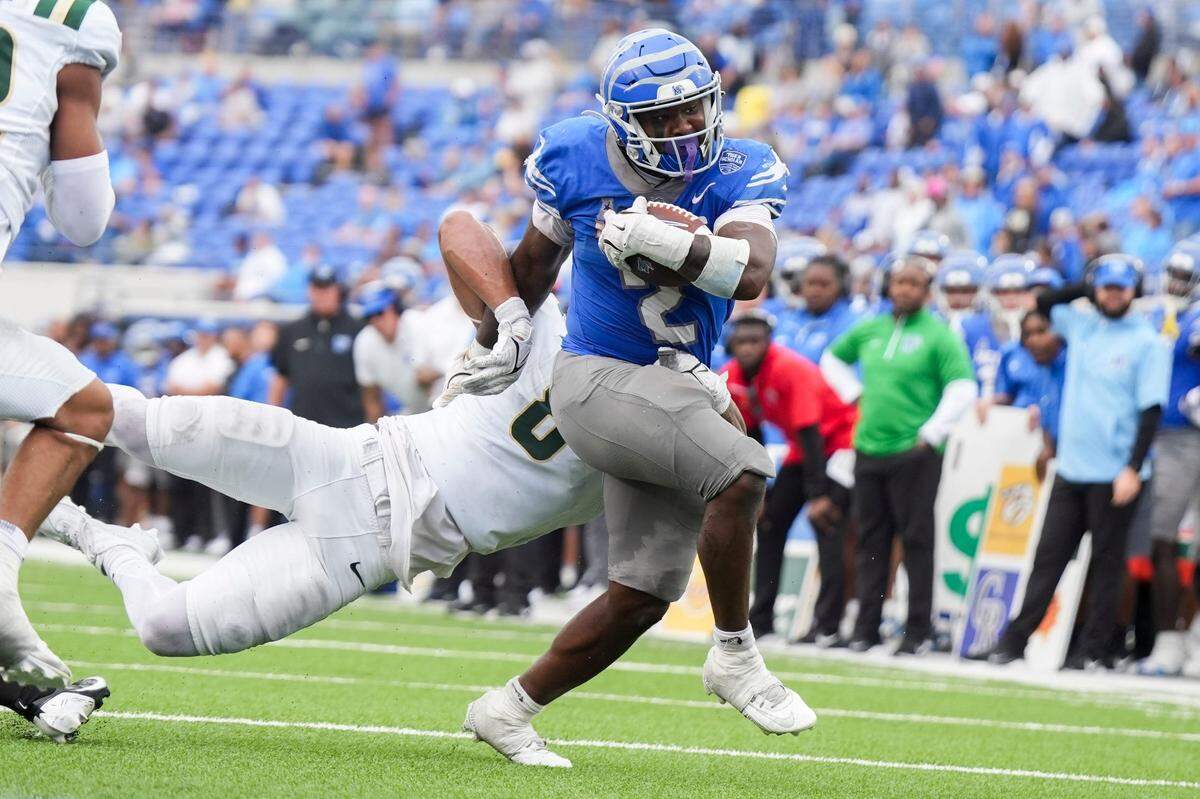 Memphis’ Mario Anderson Jr. (2) shakes a tackle from Charlotte’s linebacker Cam Burden (8) as he runs with the ball during the game between Charlotte and the University of Memphis at Simmons Bank Liberty Stadium on Saturday, October 26, 2024.