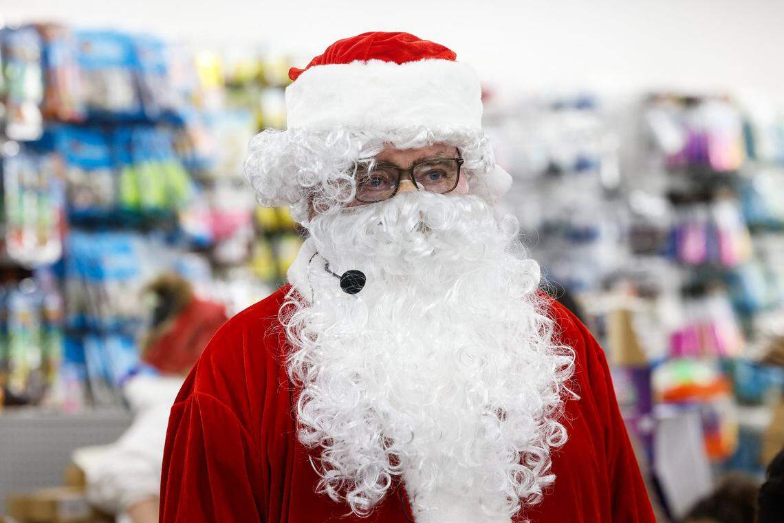 Joe Mayes, an 80-year-old Army veteran and volunteer DJ on 91.7FM WSGE out of Gaston College, dresses as Santa Claus as he and a friend host a “secret santa” gift giveaway at Might Dollar store in Gastonia, NC on Friday, December 12, 2025.