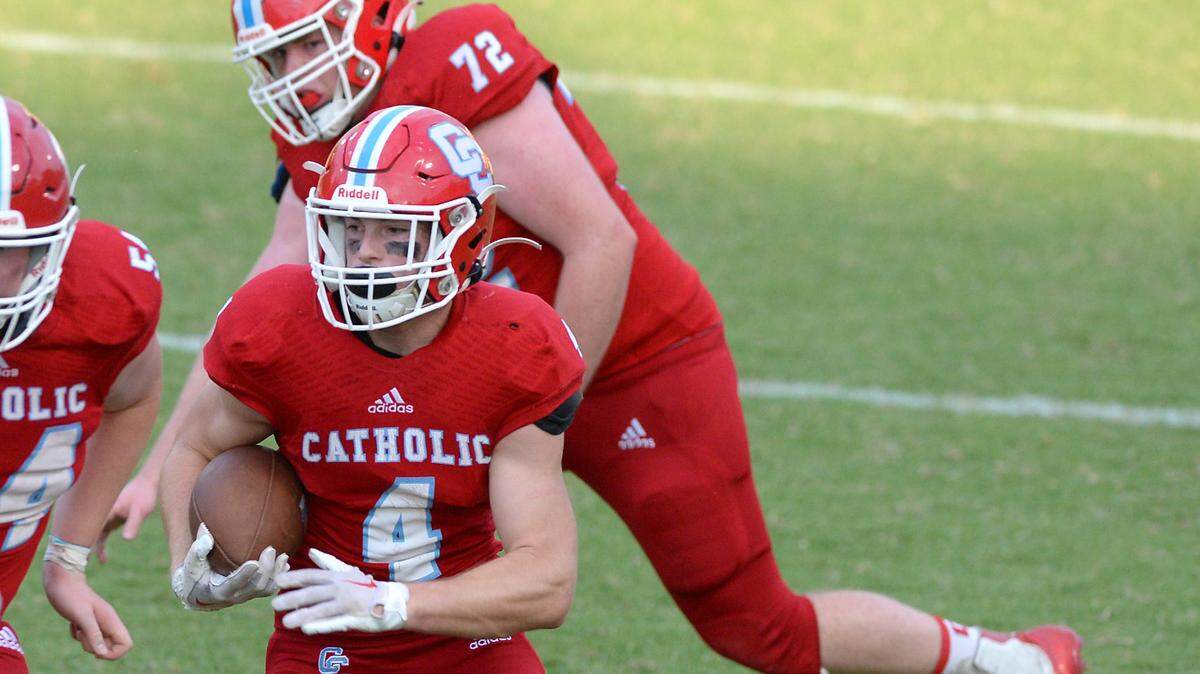 Charlotte Catholic running back Mikey Giroux, center, breaks back to the inside on a run during action on Friday, August 19, 2022 against the South Meck Sabres.