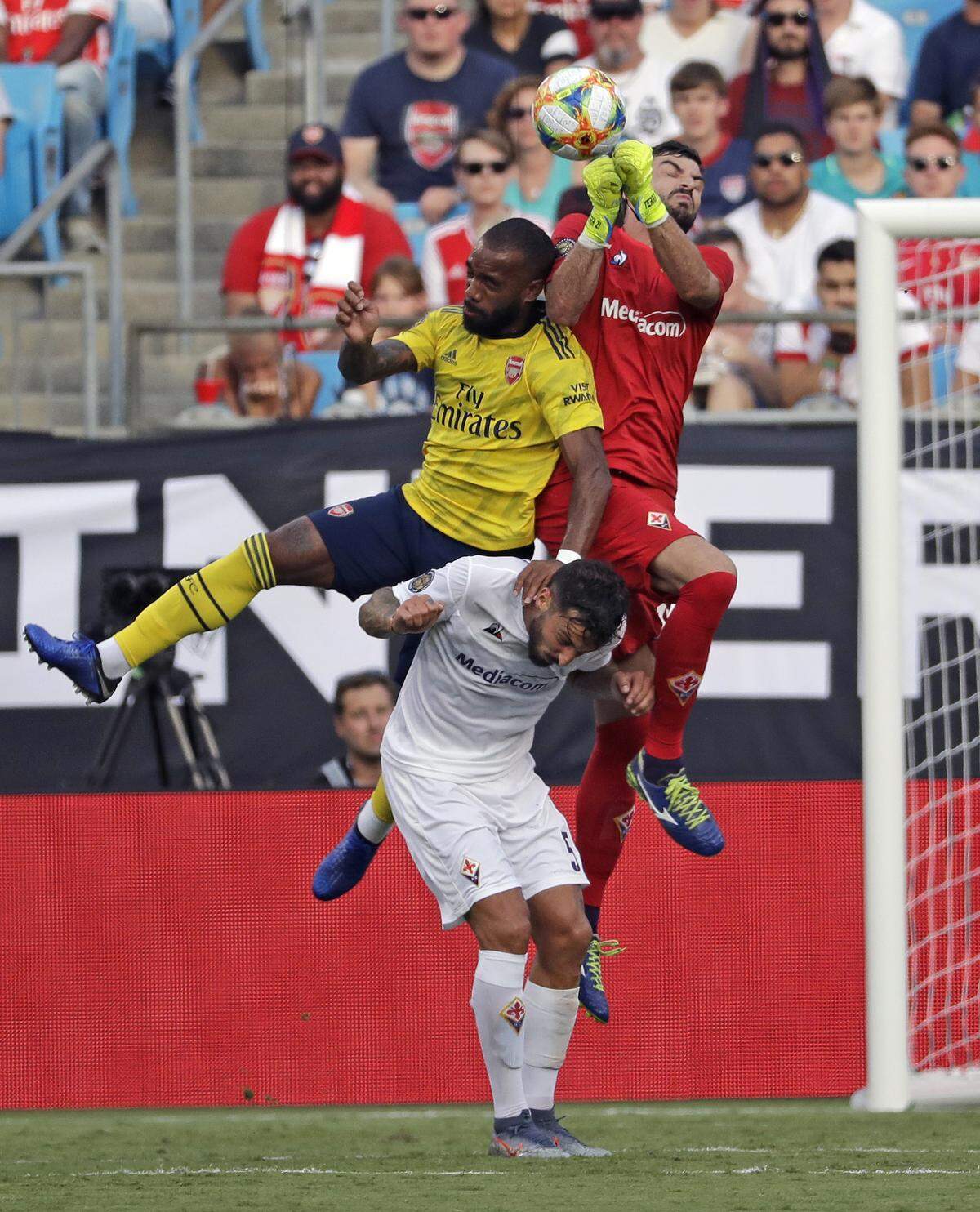 Fiorentina goalkeeper Pietro Terracciano, top right, leaps over teammate Federico Ceccherini and Arsenal’s Alexandre Lacazette to punch out the ball during the second half of an International Champions Cup match in Charlotte on Saturday.