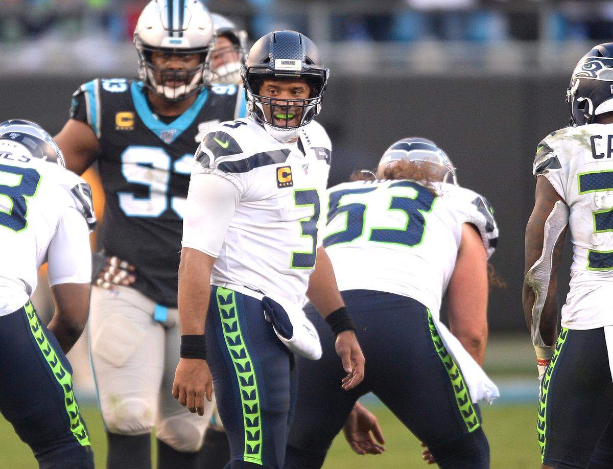Seattle quarterback Russell Wilson turns toward the backfield and smiles in the closing moments of the Seahawks’ 30-24 win over Carolina Sunday.