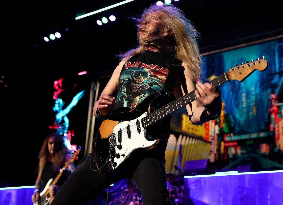 Iron Maiden guitarist Janick Gers’ hair covers his face as he and other members of the band perform at the Spectrum Center.