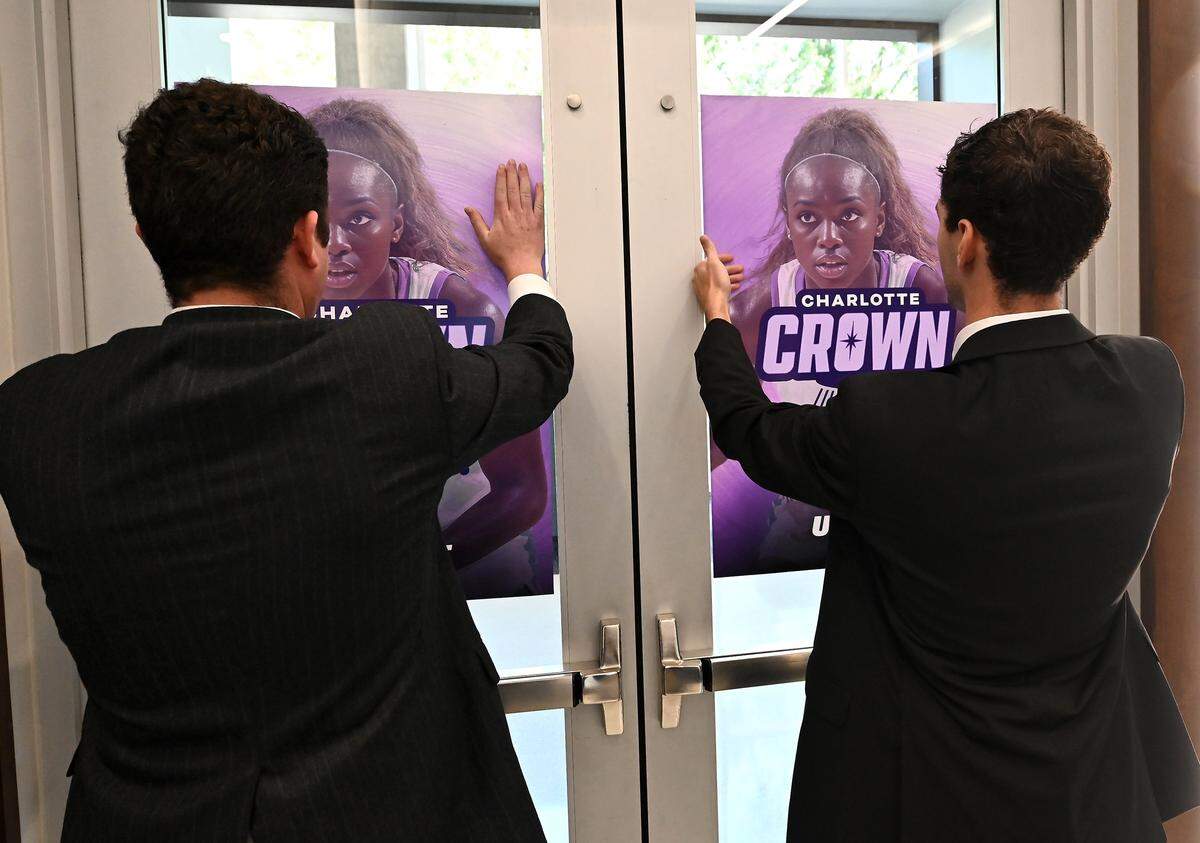 Personnel hang posters for the new Charlotte Upshot League women's team the Charlotte Crown during a press conference on Thursday, October 9, 2025 in Charlotte, NC.