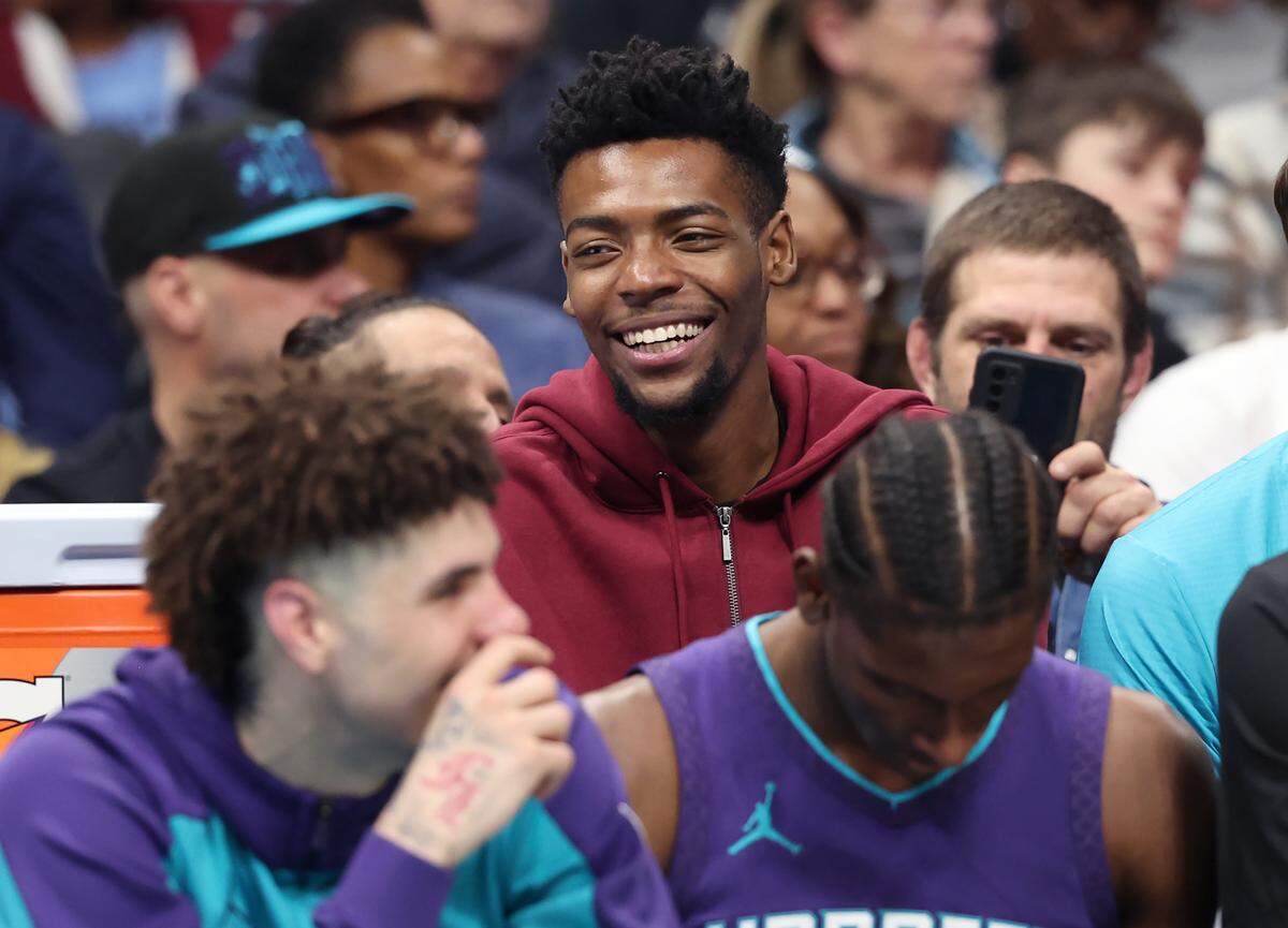 Injured Charlotte Hornets forward Brandon Miller, center, sits behind his teammates during action against the Dallas Mavericks at Spectrum Center in Charlotte, NC on Monday, January 20, 2025.