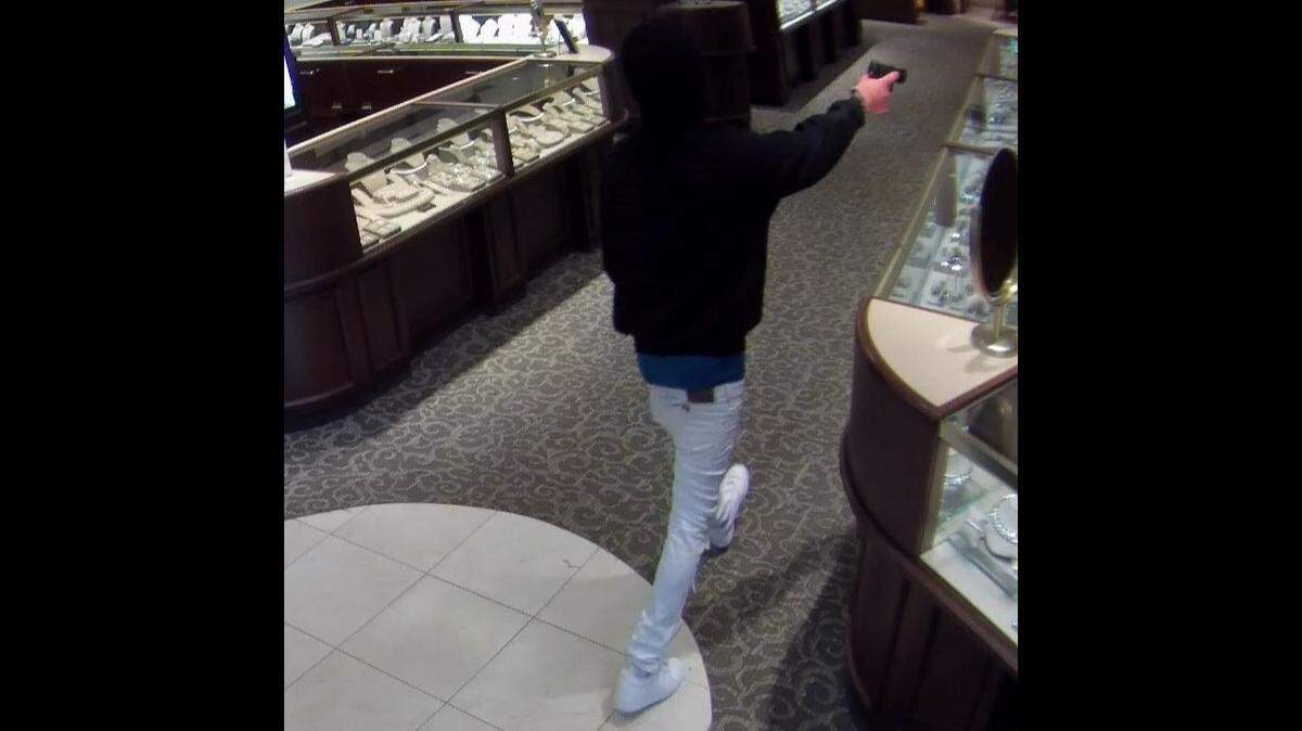 One of three masked robbers displays what appears to be a handgun during a noontime heist at a Fink’s Jewelers in the Birkdale Village mixed-use community, off Interstate 77 exit 25 in Huntersville at Lake Norman Tuesday, July 11, 2023.