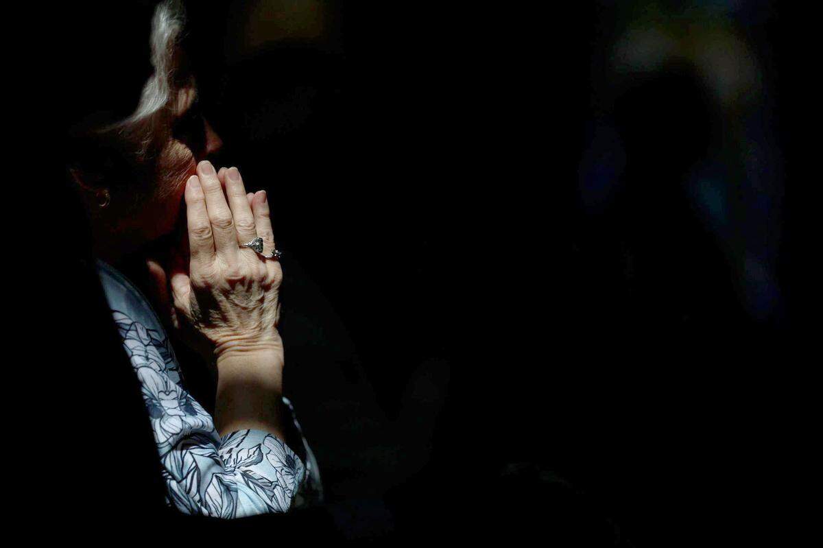 An attendee prays during Michael T. Martin’s ordination at Saint Mark Catholic Church in Huntersville on May 29, 2024.