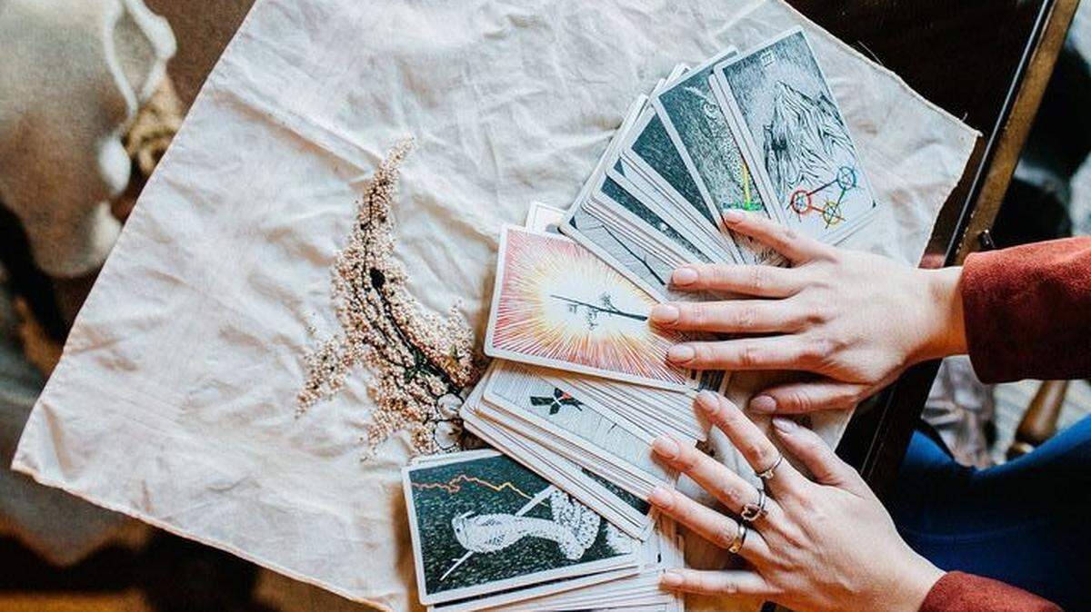 Mariah Oller, a professional tarot card reader in Charlotte, shows some of the illustrated cards in a tarot deck.