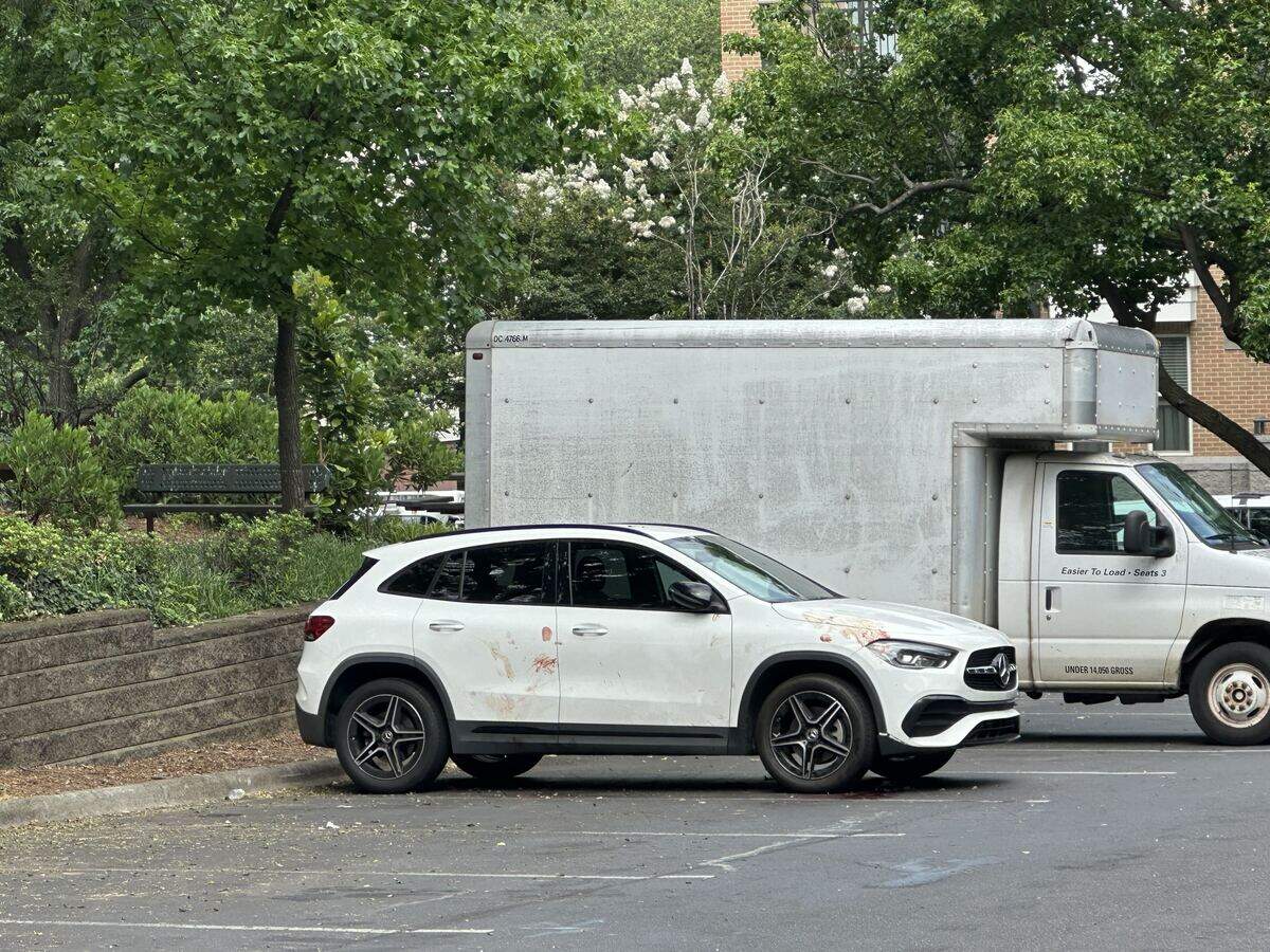 Police towed away one vehicle from the scene that was parked next to another covered in blood.