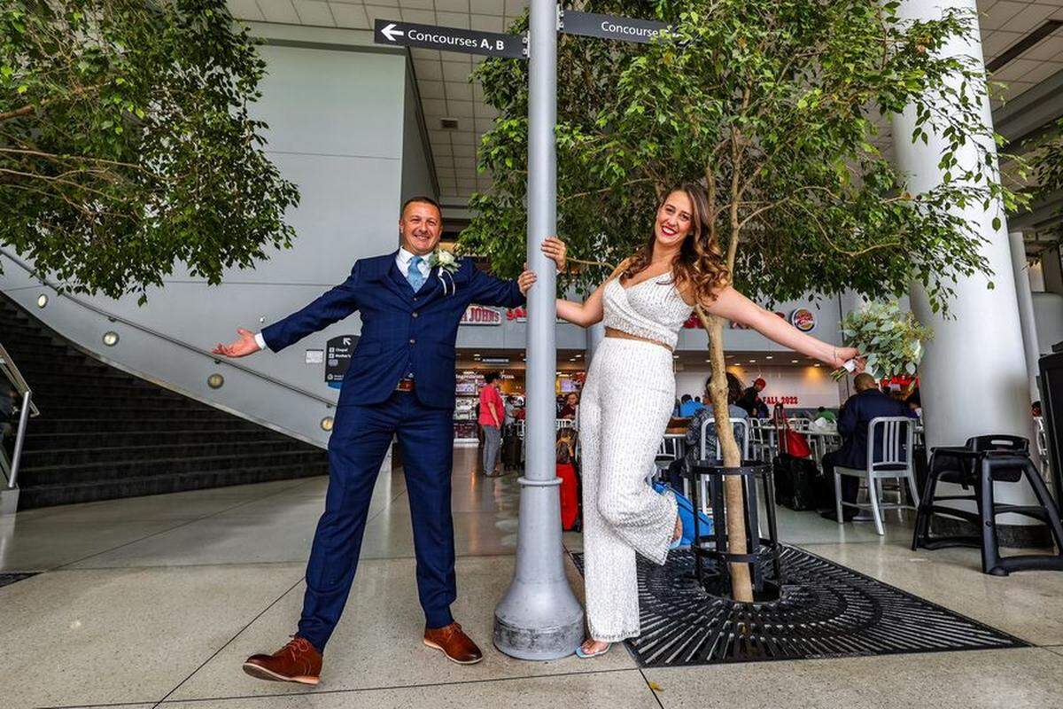 Elizabeth Evers and Adam Johnson celebrate their wedding in the Atrium of Charlotte Douglas International Airport on Sept. 9, 2022.