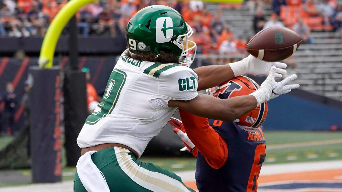 Charlotte wide receiver Elijah Spencer catches a touchdown pass from quarterback Chris Reynolds as Illinois defensive back Tony Adams defends during the first half of an NCAA college football game Saturday, Oct. 2, 2021, in Champaign, Ill. (AP Photo/Charles Rex Arbogast)