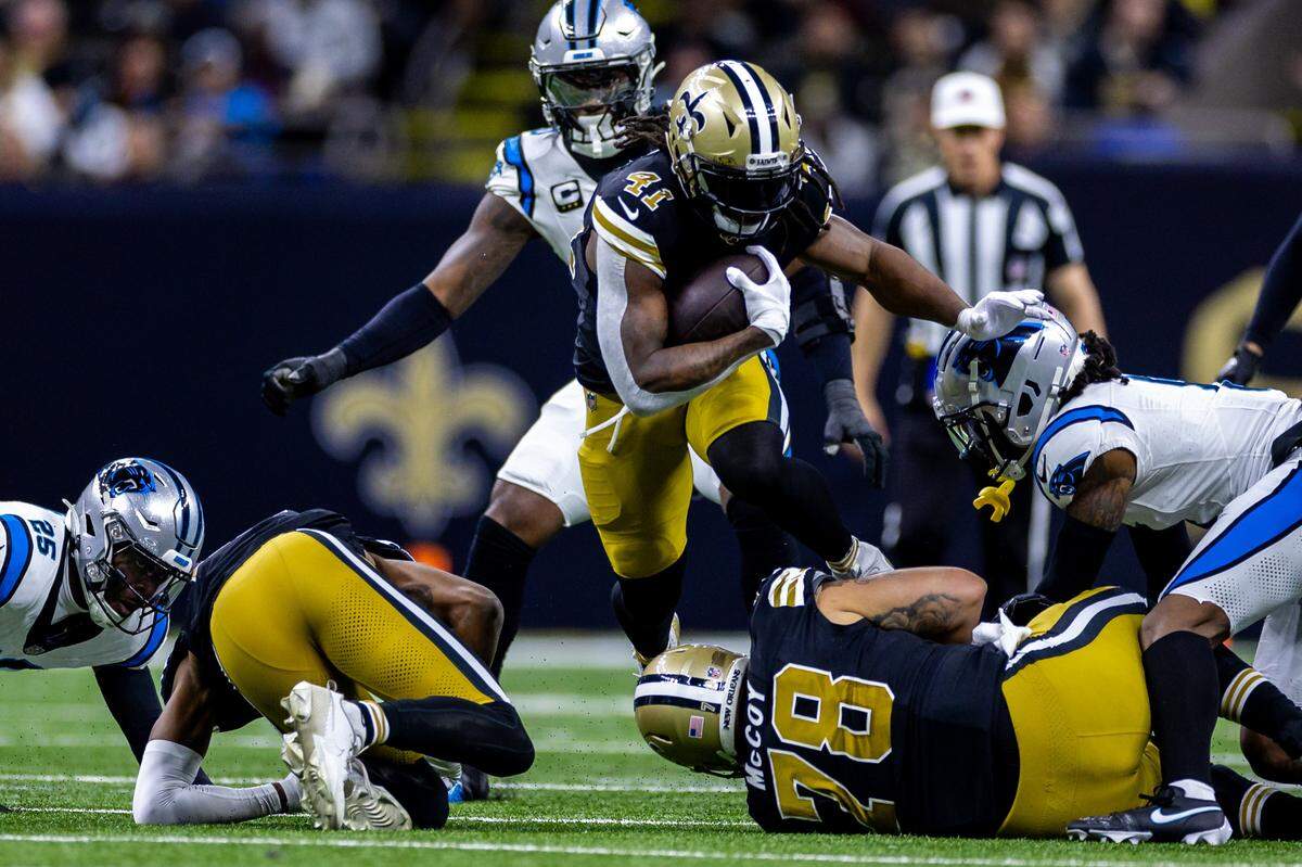Dec 10, 2023; New Orleans, Louisiana, USA; New Orleans Saints running back Alvin Kamara (41) leaps over New Orleans Saints center Erik McCoy (78) on a run against Carolina Panthers safety Xavier Woods (25) during the first half at the Caesars Superdome. Mandatory Credit: Stephen Lew-USA TODAY Sports