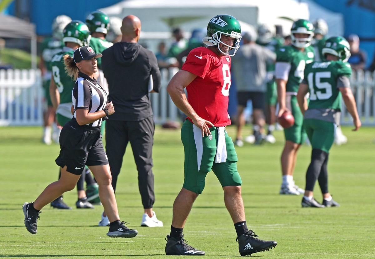 New York Jets quarterback Aaron Rodgers, center, smiles as he walks across a field during the team’s joint practice with the Carolina Panthers on Thursday, August 15, 2024 in Charlotte, NC.