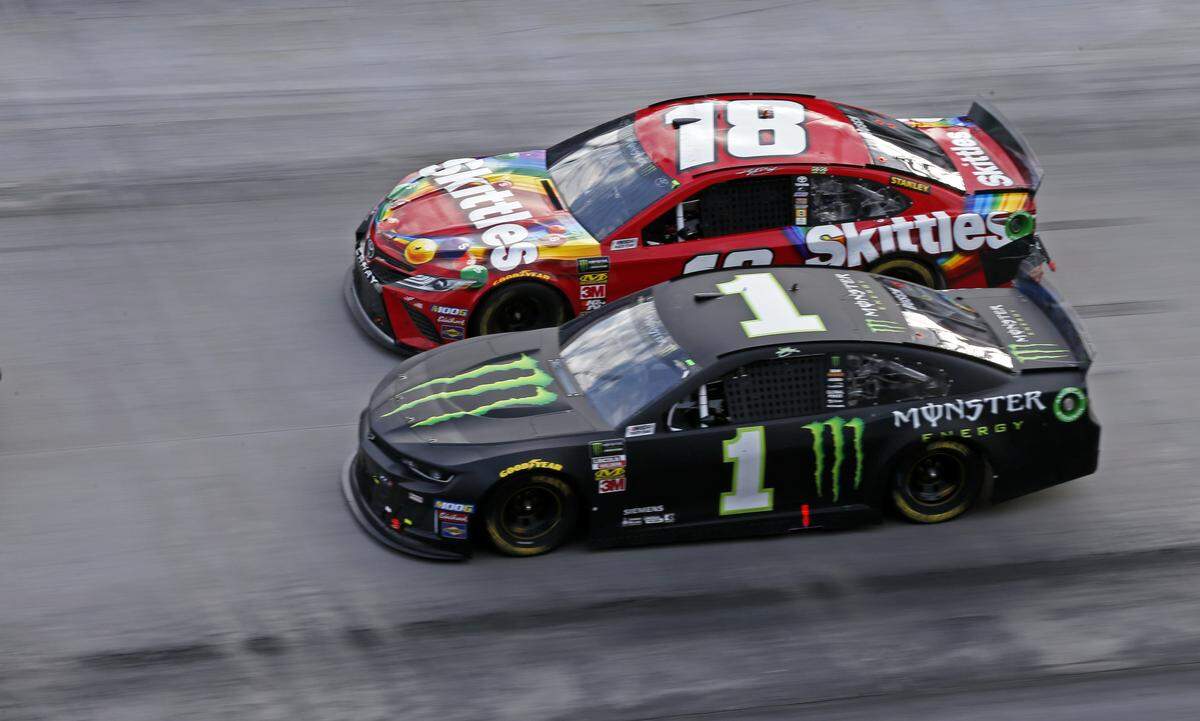 Kyle Busch (18) drives next to his brother Kurt Busch (1) on a restart during a NASCAR Cup Series auto race, Sunday, April 7, 2019, in Bristol, Tenn. (AP Photo/Wade Payne)