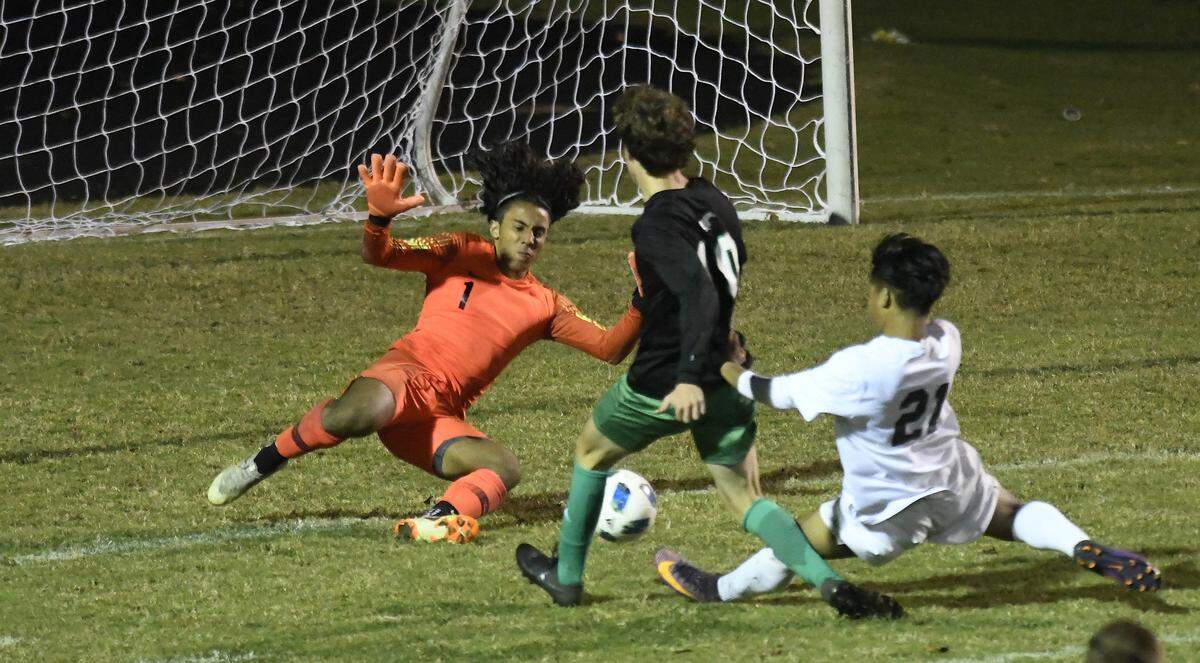Myers Park's Carter Hensley (10) takes a shot against Independence’s Lian Van (21) and goalkeeper Ro Lian (1) during a 2018 playoff game.