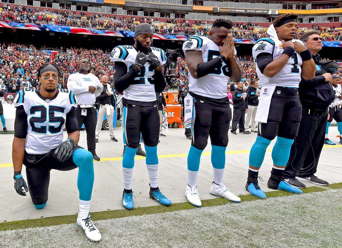 Carolina Panthers safety Eric Reid, left, takes a knee during the national anthem during a 2018 game. Owner David Tepper decided to sign Reid, although his kneeling had made him a lightning rod for criticism in some quarters.