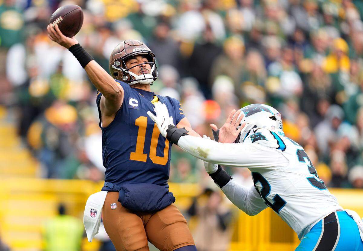 Green Bay’s Jordan Love throws a pass while pressured by Carolina’s Trevin Wallace during the third quarter of Sunday’s game.