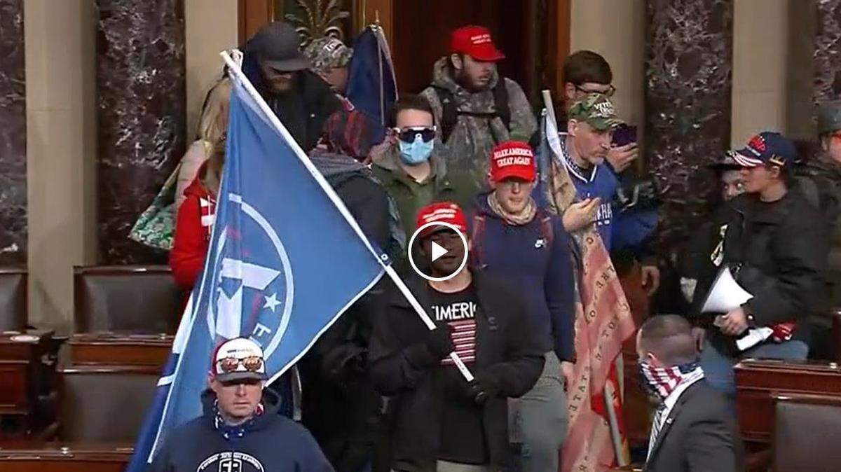 Chris Carnell of Cary, (center right and wearing a red cap) has become the latest North Carolinian charged in connection with the Capitol riot. His companion, David Bowman of Raleigh (center left in blue mask) has been interviewed by the FBI and recommended for charges, but had not been arrested as of Friday.