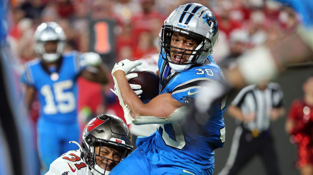 Dec 3, 2023; Tampa, Florida, USA; Carolina Panthers running back Chuba Hubbard (30) runs with the ball as Tampa Bay Buccaneers safety Antoine Winfield Jr. (31) defends during the second half at Raymond James Stadium. Mandatory Credit: Kim Klement Neitzel-USA TODAY Sports