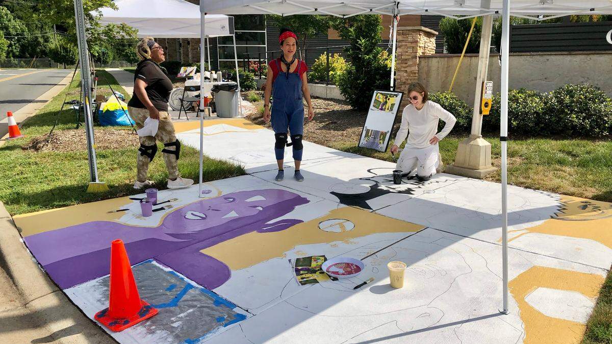 Bunny Gregory, MyLoan Dinh and MoRA board chair Kathy Hill collaborate on a sidewalk mural near Oakhurst STEAM Academy.