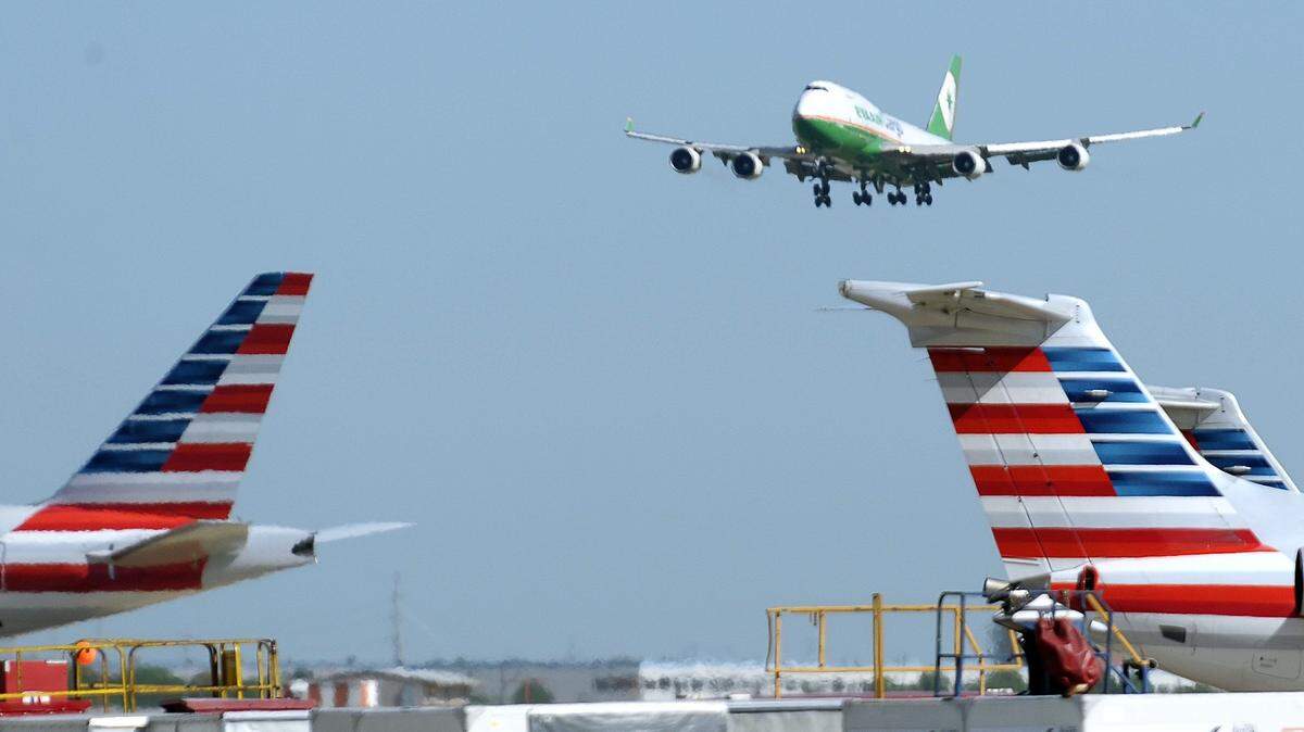 In this file photo from 2016, an EVA Air Cargo 747 lands over American Airlines planes at Dallas-Fort Worth International Airport. An African American woman said she felt humiliated after American Airlines called police on her because a white passenger complained about her arm touching hers on a Raleigh-Durham flight last week.