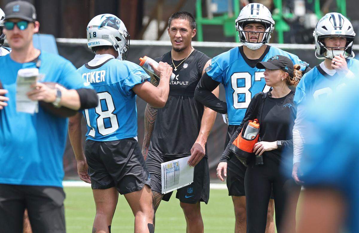 Carolina Panthers wide receiver Tetairoa McMillan, center, talks to wide receiver Jalen Coker, left, during a break in the team's first open workout on Tuesday, May 26, 2026.