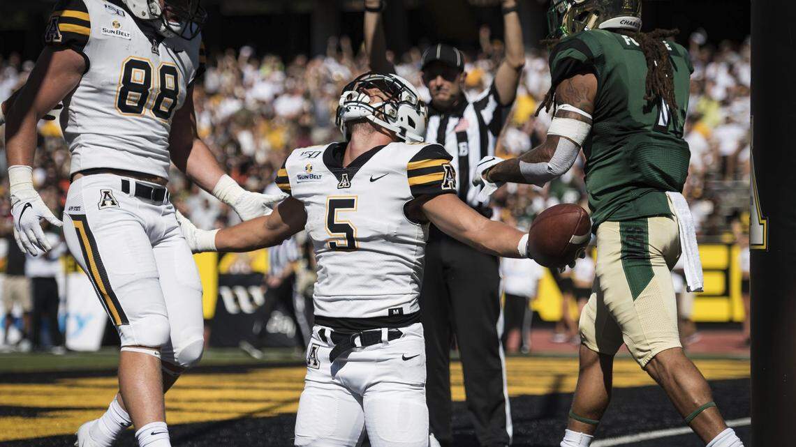 Appalachian State wide receiver Thomas Hennigan (5) is joined by teammate tight end Henry Pearson (88) while celebrating in the end zone after making a reception for a touchdown over UNC Charlotte defensive back Jacione Fugate (7, right) in the first quarter of an NCAA college football game on Saturday, Sept. 7, 2019, at Kidd Brewer Stadium in Boone, N.C. (Allison Lee Isley/The Winston-Salem Journal via AP)