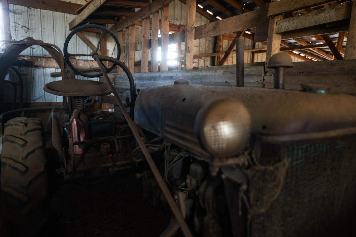 Old farm equipment, such as this vintage tractor, is heavily covered in dust as it sits in a barn on Westmoreland Farm. 