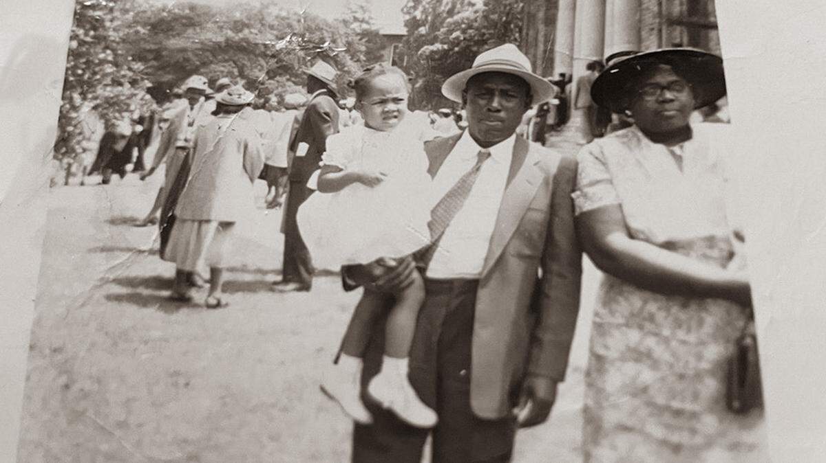 Mangie McQueen stands next to Catherine McQueen and holds their eldest granddaughter, Fayon Fisher Thompson, daughter of Clotelle McQueen Fisher.