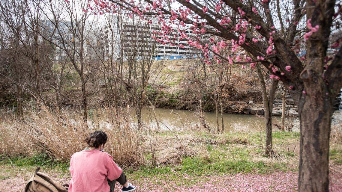A woman sits by a Sugar Creek in Charlotte, NC, on Saturday, February 25, 2021.