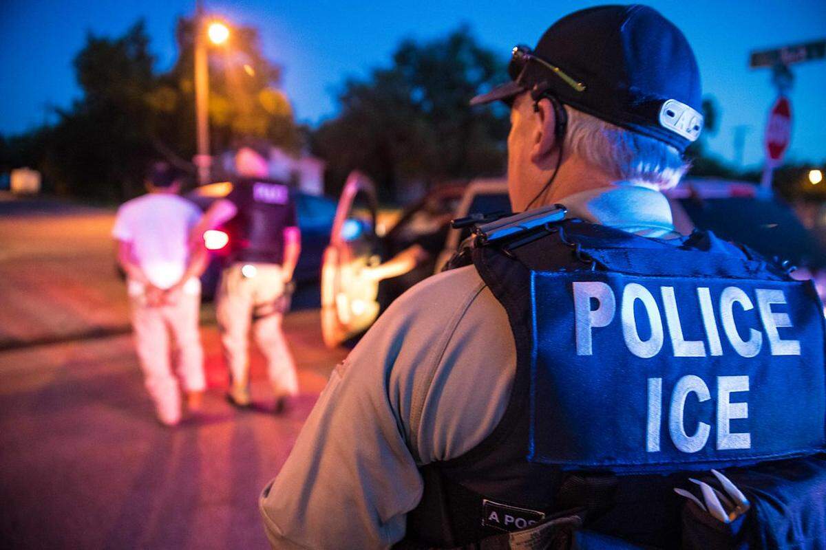 A U.S. Immigration and Customs Enforcement officer observes a detainment.