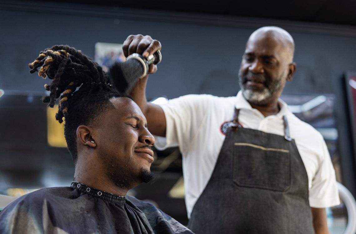 Brian Mack, right, cuts his son’s hair, B.J., at House of Hoops Barbershop in Charlotte, N.C., on Monday, July 1, 2024.
