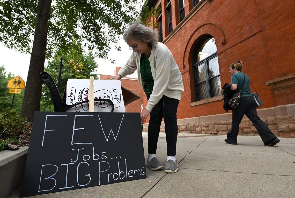 Lynne Taylor adjusts her sign opposing a proposed data center on Sept. 15 outside City Hall in Statesville. The City Council approved data center rezoning for Stamey Farms property in western Iredell County.