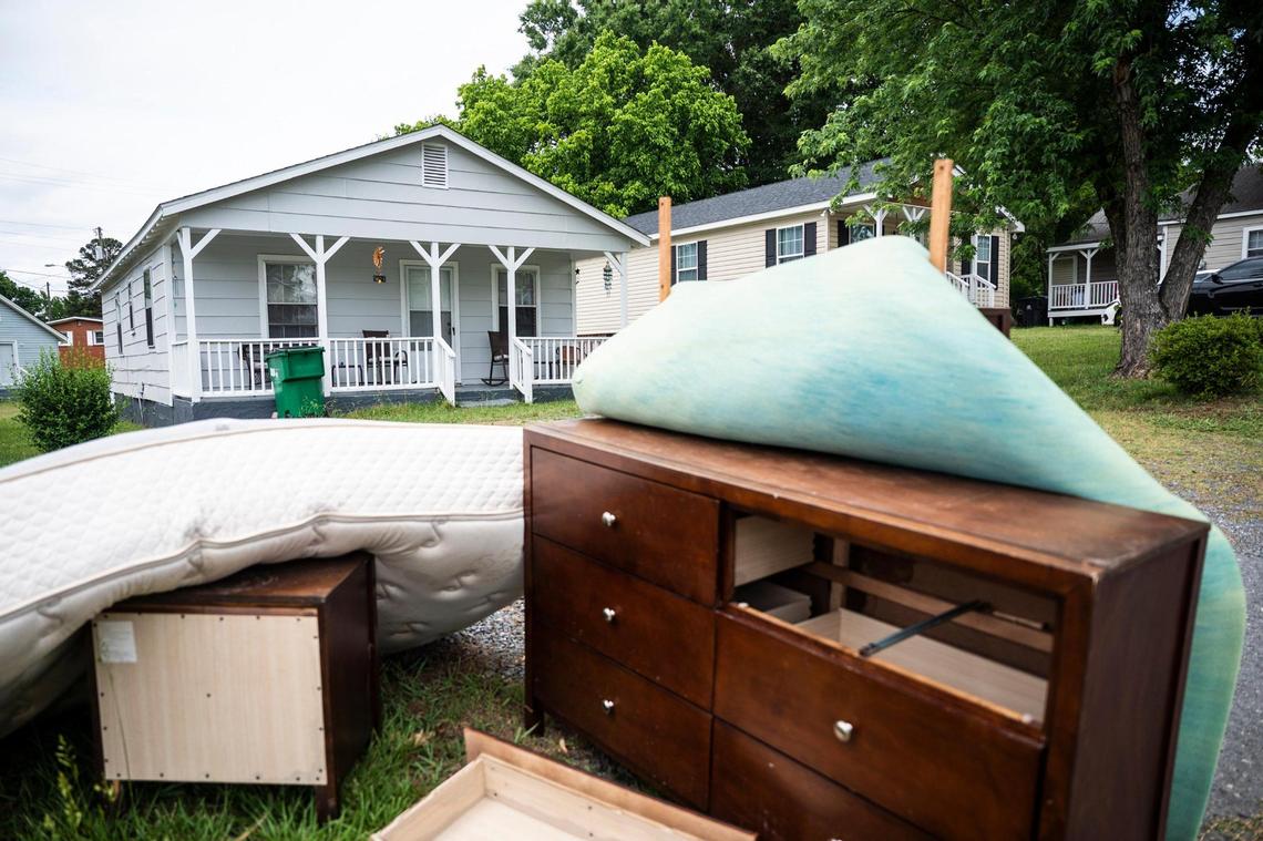 Discarded personal effects belonging to Debbie Briscoe sit in a pile outside of her home on Yandle Lane in the Sterling community on Tuesday, May 24, 2022 in Charlotte. Briscoe, along with many others in the neighborhood, were given thirty days to vacate their rental homes after they were bought by a developer.