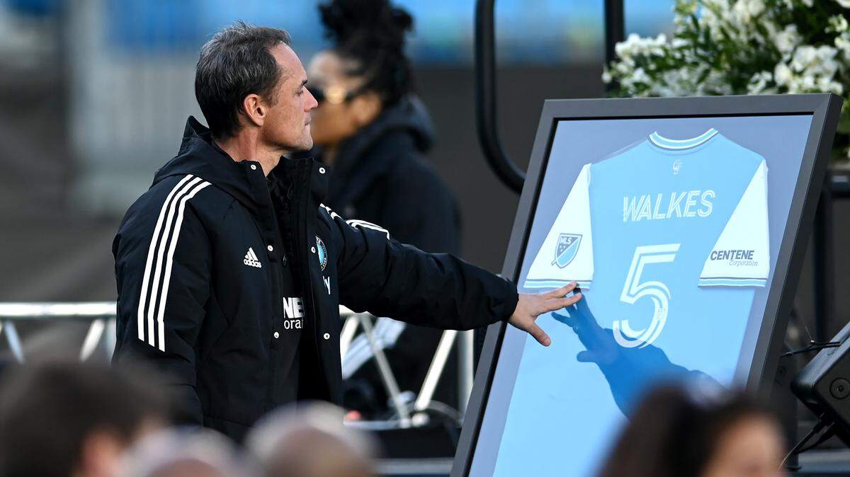 Charlotte FC head coach Christian Lattanzio reaches out to touch the framed jersey of Anton Walkes during a celebration of Walkes’ life at Bank of America Stadium on Tuesday, January 24, 2023. Walkes was a Charlotte FC defender who died from injuries he suffered in a boating accident near the Miami Marine Stadium Basin in Florida on Thursday, January 19, 2023.