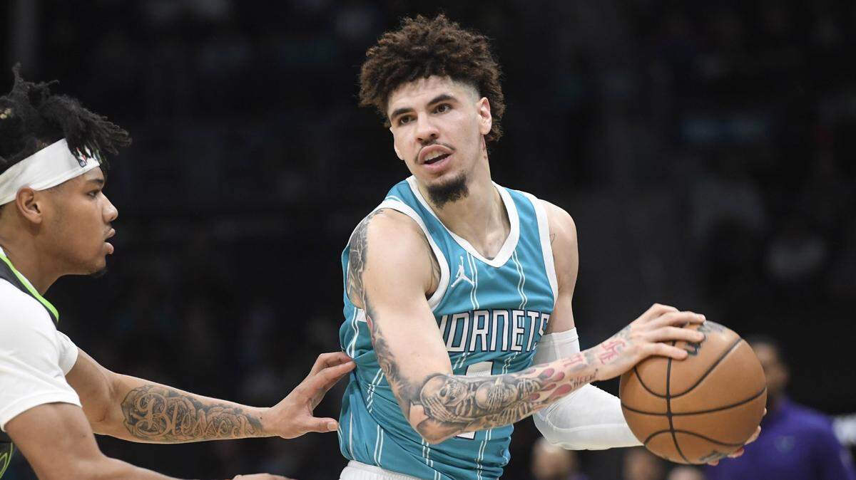 Charlotte Hornets guard LaMelo Ball (1) controls the ball as he is defended by Minnesota Timberwolves guard Terrence Shannon Jr. (00) during the first half at the Spectrum Center.