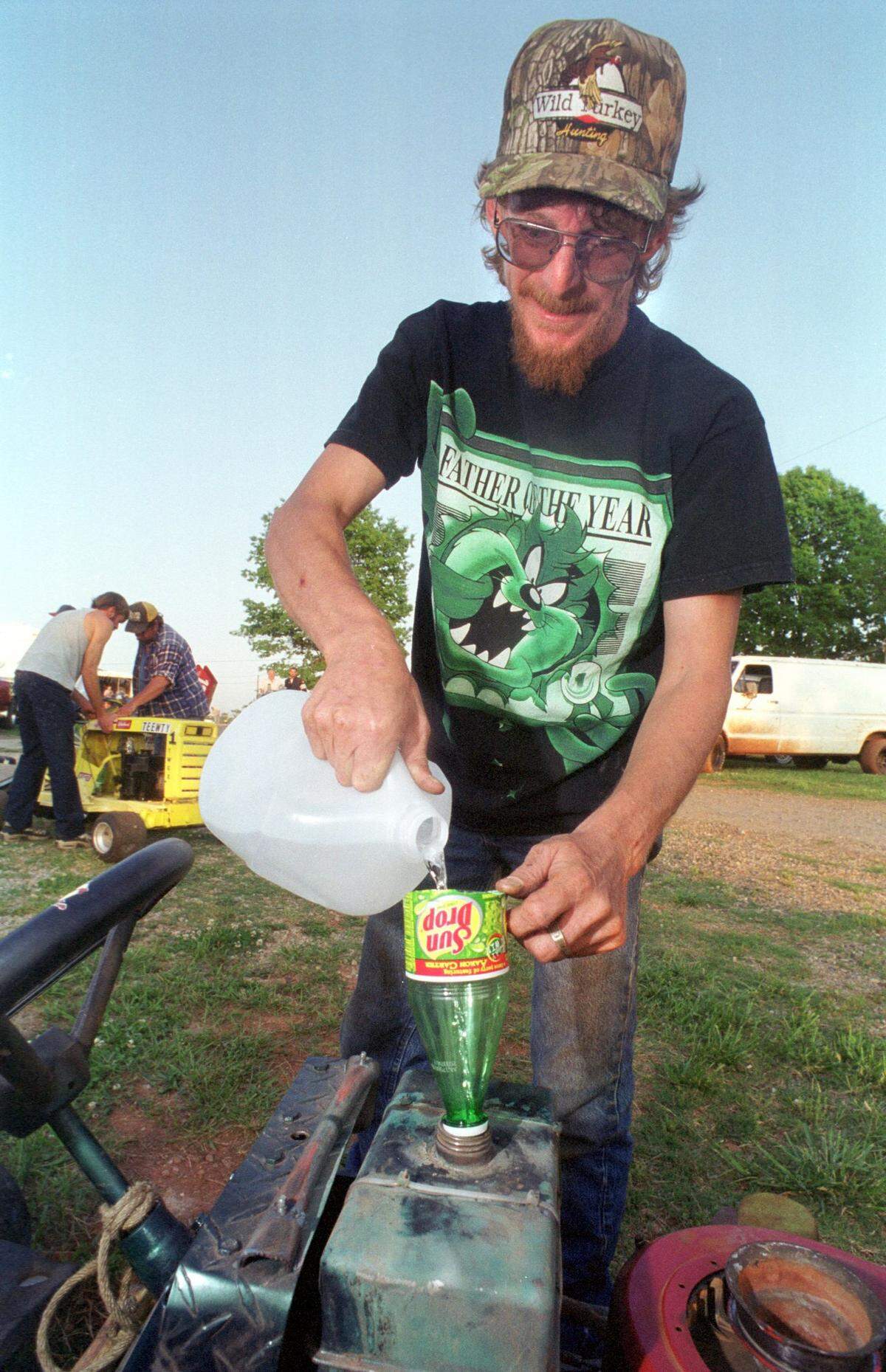 In May 2020, Tim Hefner fuels his racing lawnmower with methanol poured through a Sun Drop soda bottle funnel before Friday night's races at Pine Valley Speedway.